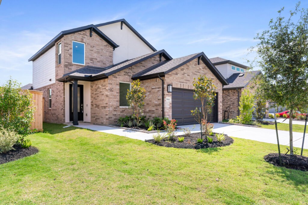 Two-story brick home with landscaped front lawn
