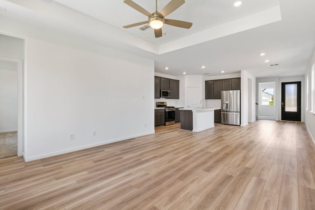 Open living area with ceiling fan, looking toward the kitchen