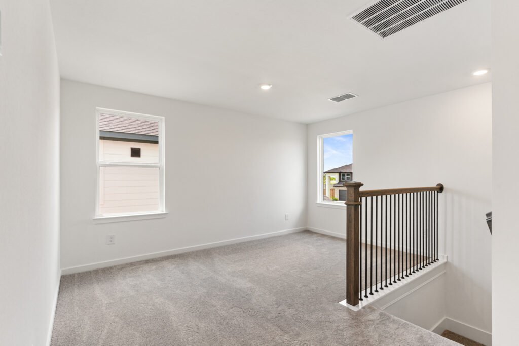 Carpeted bedroom with stair railing