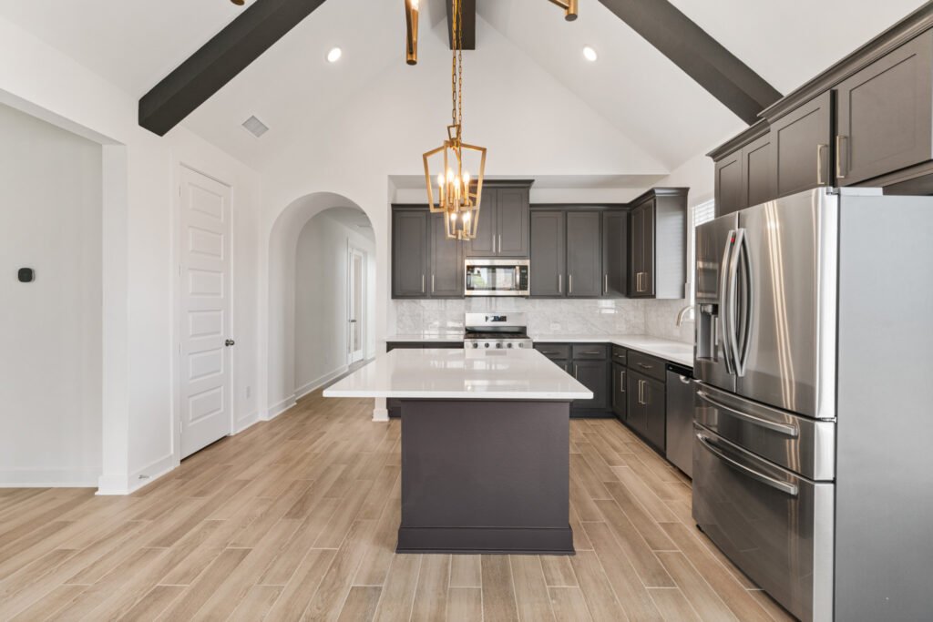 Kitchen with dark cabinets, island and lantern pendant