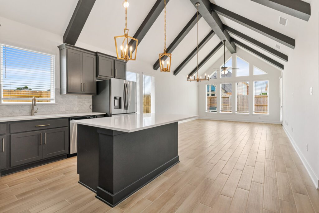 Vaulted kitchen and living room with exposed beams and chandeliers